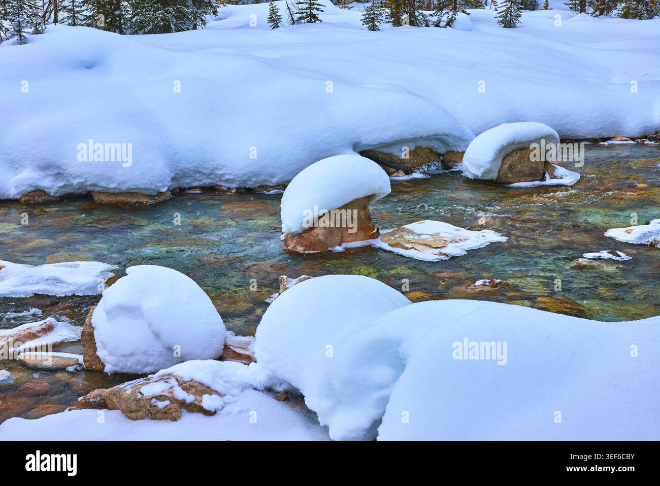 Boulders innevati e Winter River nell'incontaminata area naturale canadese Foto Stock