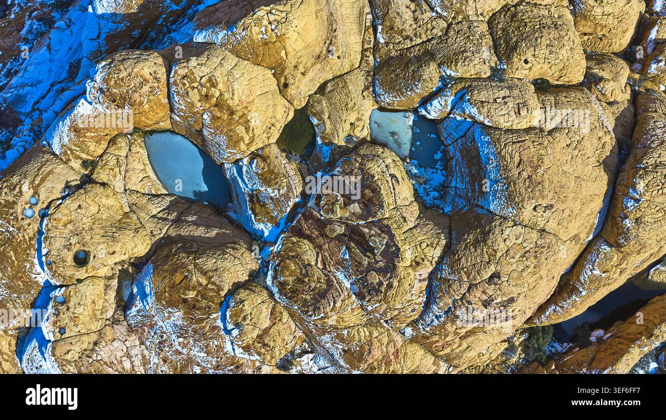 Piscine aeree ghiacciate e neve sulle formazioni rocciose rosse dall'alto verso il basso. Foto Stock