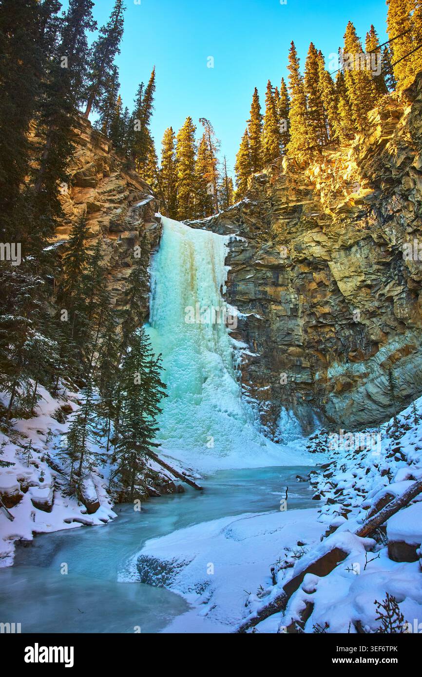 Cascata ghiacciata e fiume Snowy nel Winter Forest Canyon Alberta Foto Stock