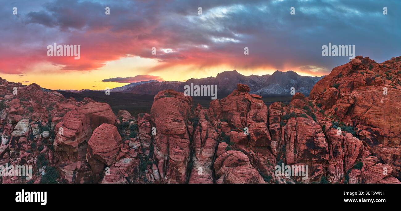 Panorama aereo al tramonto del Red Rock Canyon con formazioni caliche e picchi innevati Foto Stock