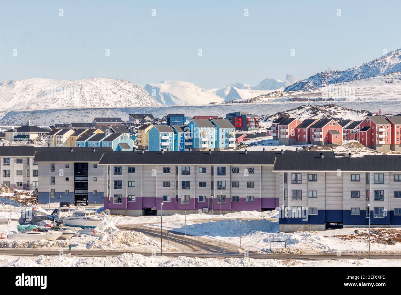 Residenza residenziale groenlandese contemporanea con bassi blocchi di appartamenti Inuit, facciate colorate e strade invernali nella capitale, Nuuk Foto Stock