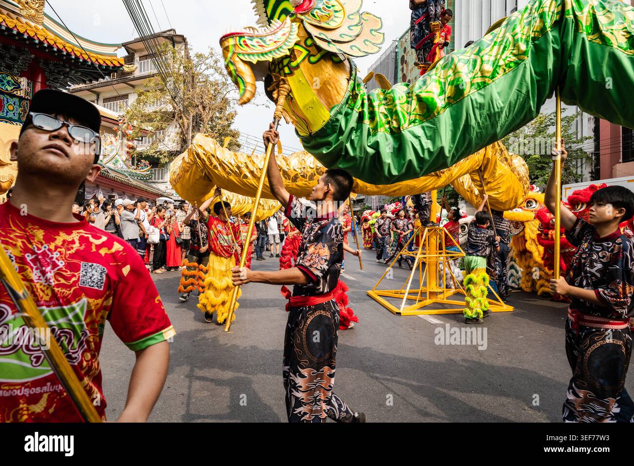 I membri del team di danza del drago si esibiscono con un burattino gigante al Festival di Primavera sulla Yaowarat Road a Chinatown, Bangkok, Thailandia Foto Stock