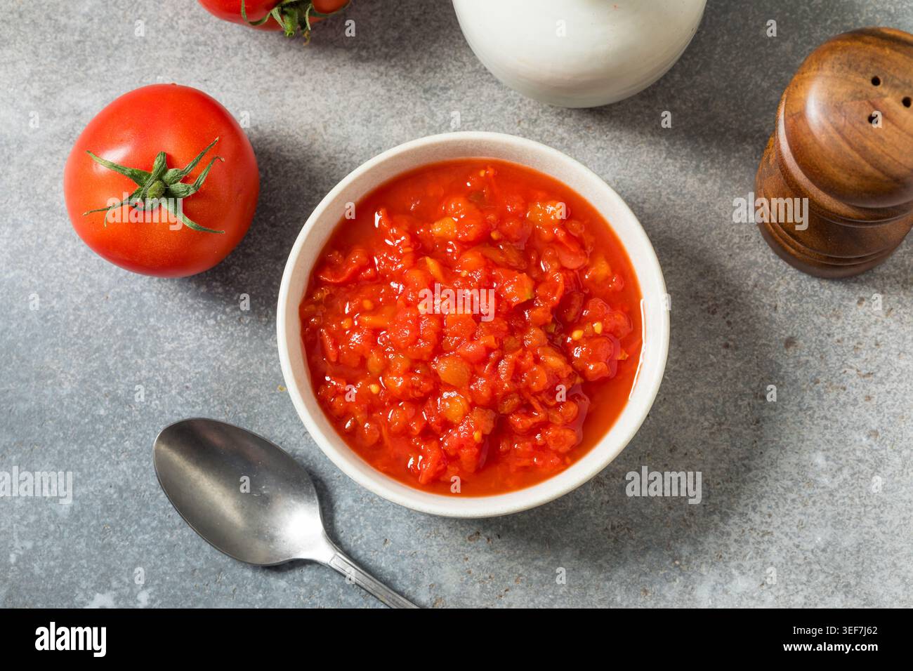 Pomodori rossi crudi in scatola schiacciati in una ciotola da cuocere Foto Stock