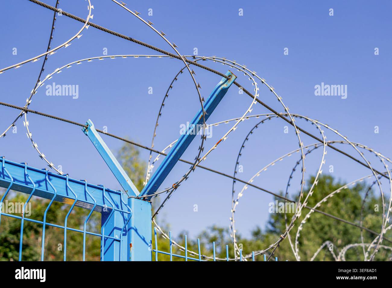 Un oggetto appositamente protetto con filo spinato contro un cielo blu Foto Stock