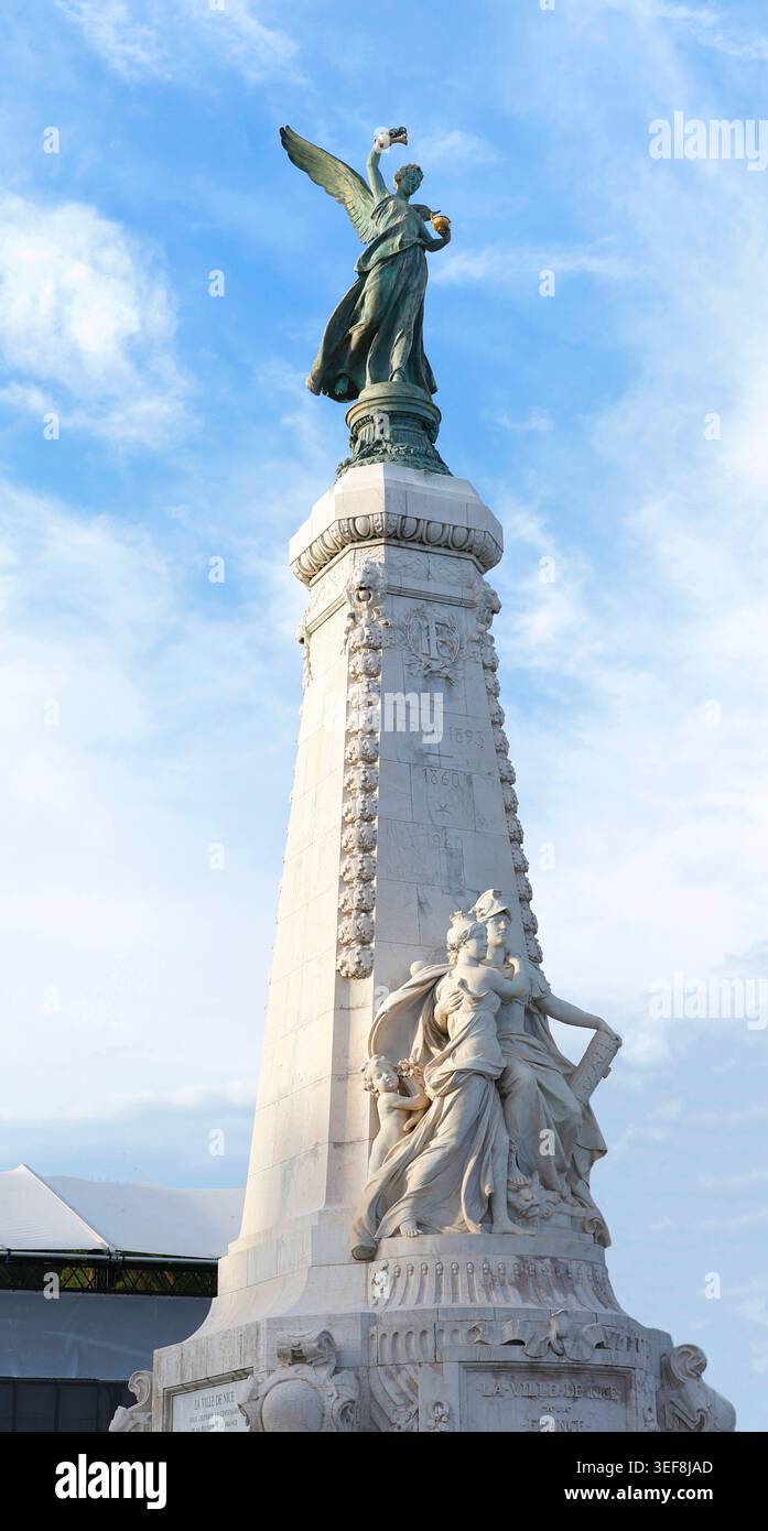 Monumento del centenario di Nizza, obelisco, statua della vittoria alata in bronzo. Figure di scultura allegoria in marmo si trovano alla base sotto uno splendido cielo blu Foto Stock