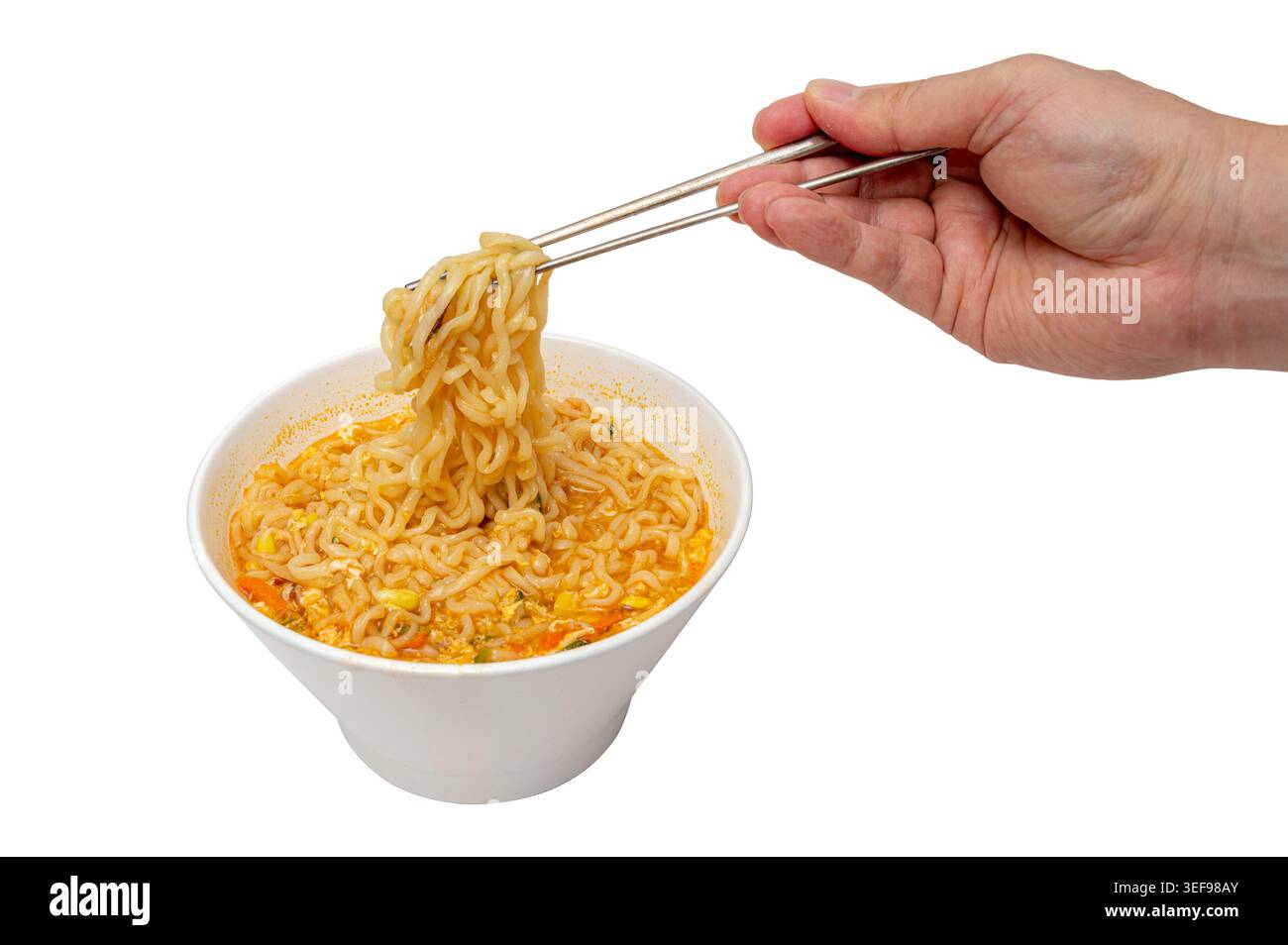 mani che tengono le bacchette con spaghetti istantanei coreani in una ciotola bianca isolata su sfondo bianco Foto Stock