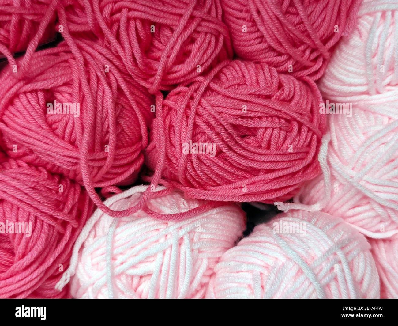 Primo piano di palle in filato multicolore impilate insieme, fibra morbida, materiale per maglieria, sfondo a cornice intera Foto Stock