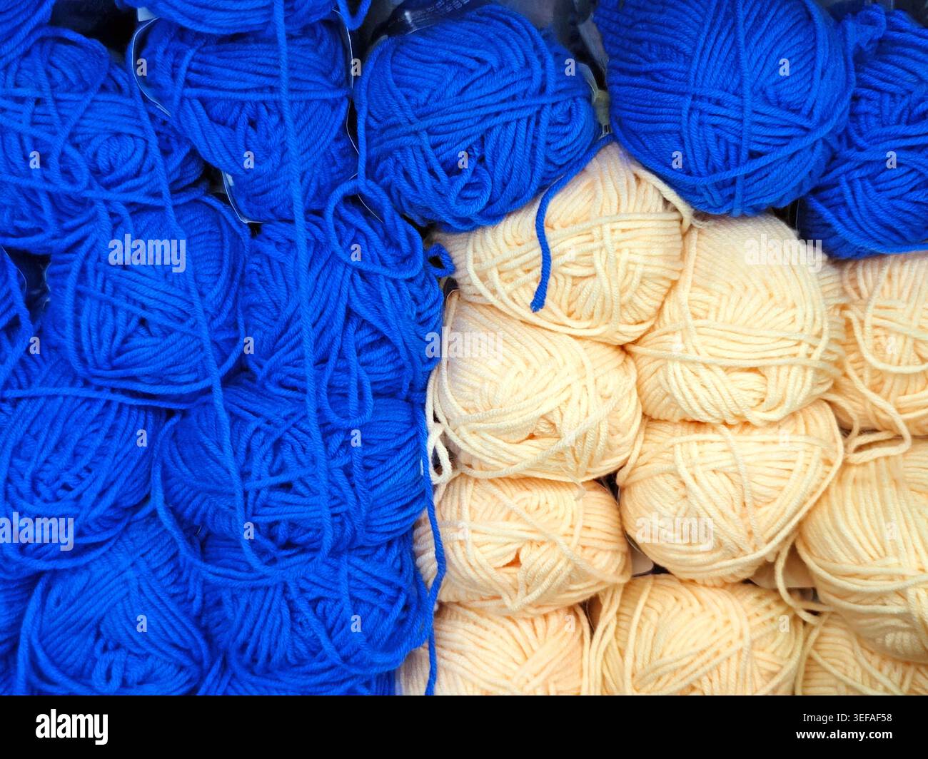 Primo piano di palle in filato multicolore impilate insieme, fibra morbida, materiale per maglieria, sfondo a cornice intera Foto Stock