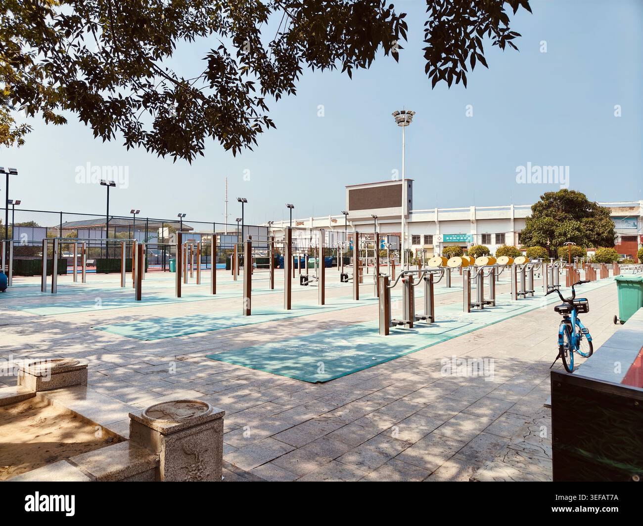 Parco pubblico all'aperto con attrezzature fitness nella città di Kaifeng nelle giornate di sole, provincia di Henan, Cina - Immagine stock catturata con smartphone