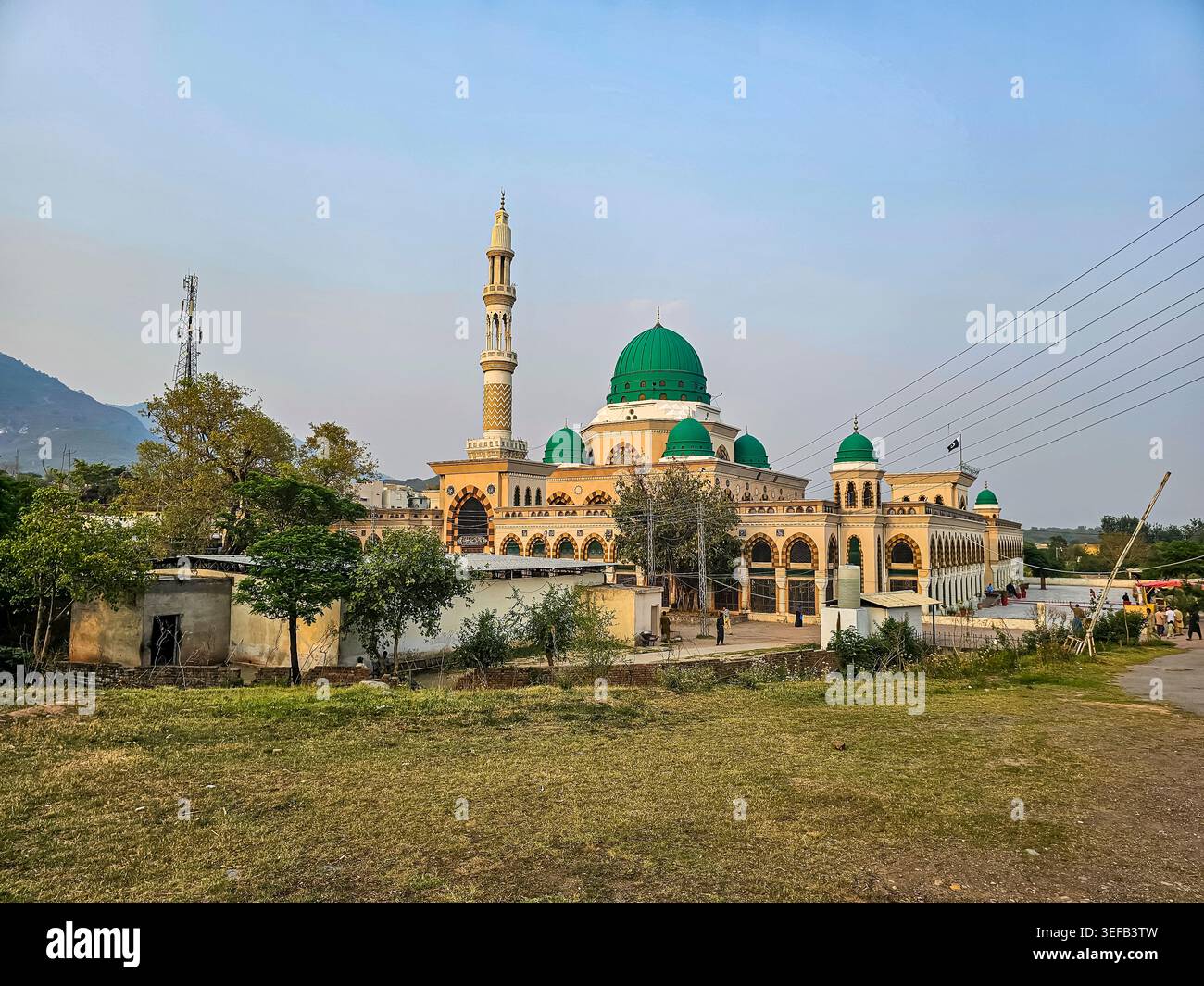Grande moschea con cupola verde e minareti circondata da alberi a Islamabad Pakistan Foto Stock