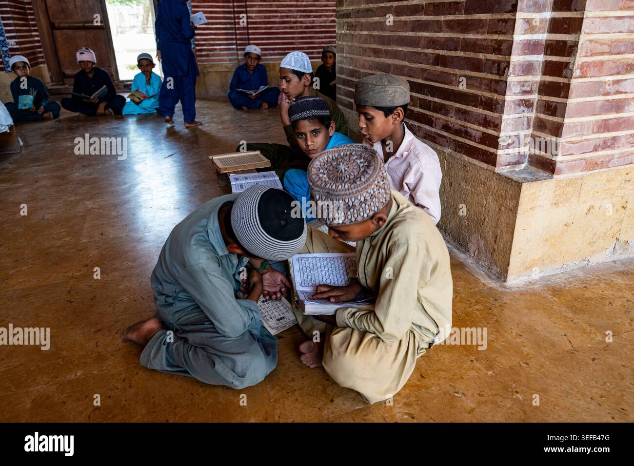 Gli studenti studiano insieme nella medressa della Moschea Shah Jahan a Sindh, Pakistan, durante una sessione di apprendimento Foto Stock
