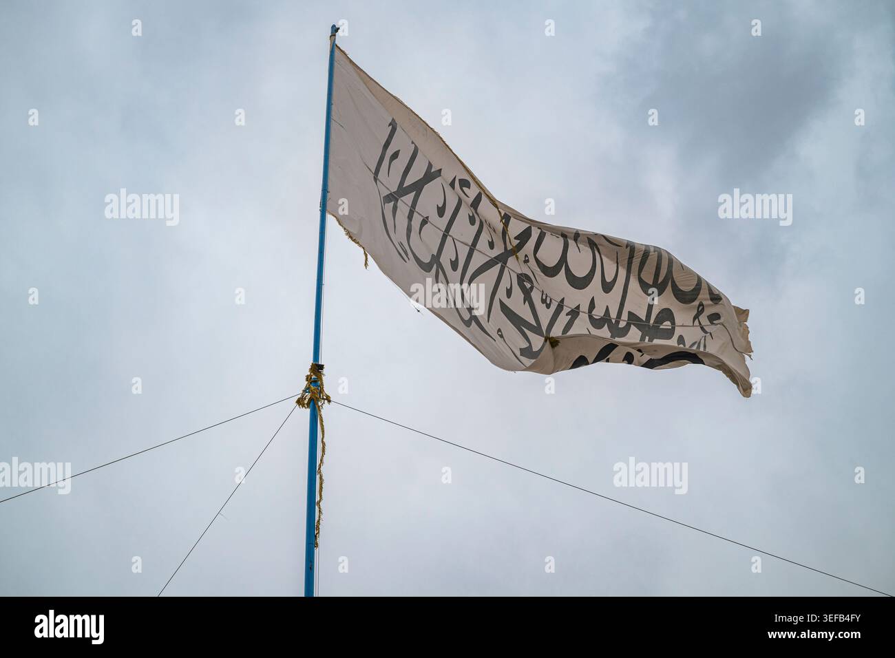 Bandiera dei talibani esposta contro il cielo in Afghanistan, che riflette la presenza del gruppo nella regione di Ghazni Foto Stock
