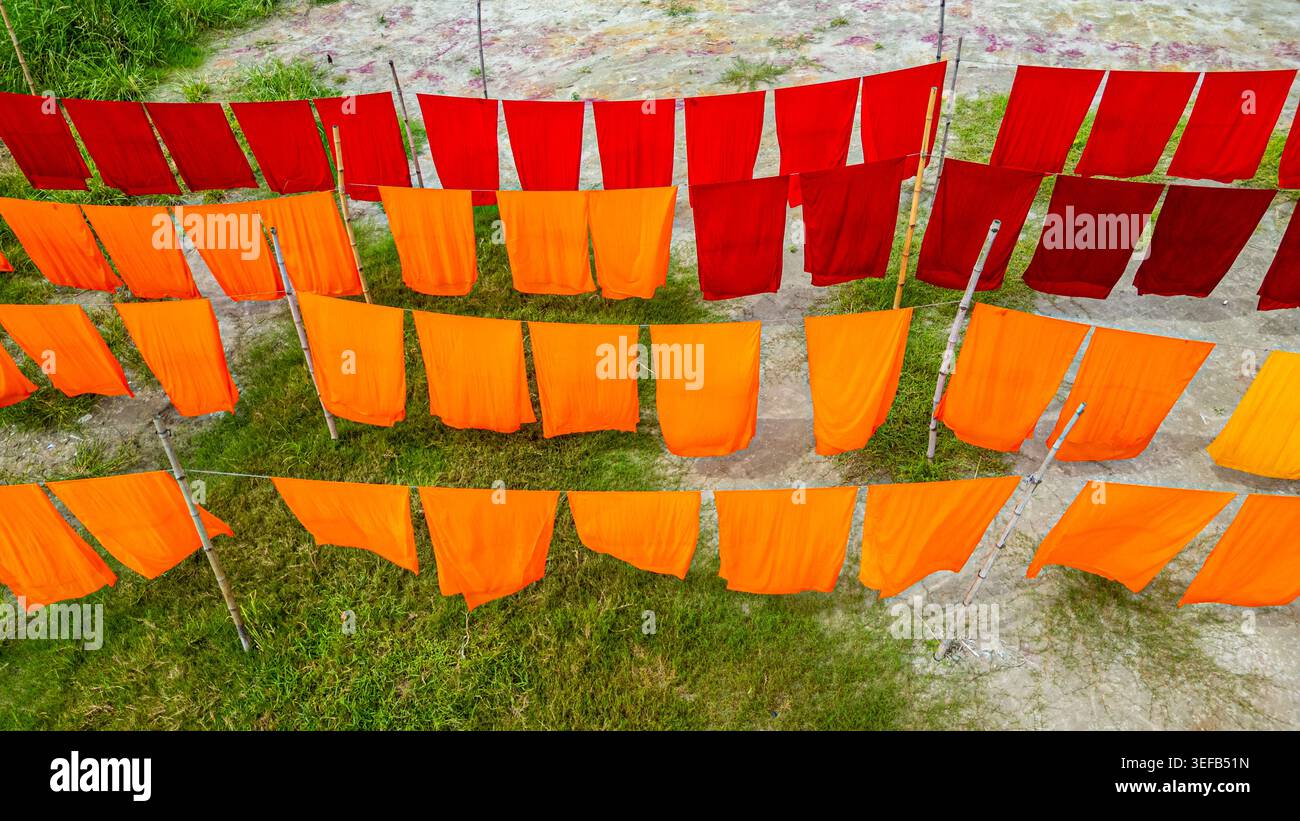 I panni appena tinti pendono per asciugarsi sotto la luce del sole in un villaggio Foto Stock