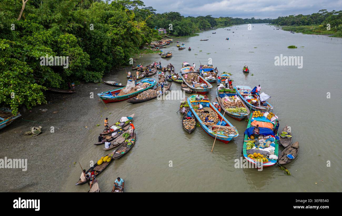 Esplorando il mercato galleggiante e il commercio locale sui canali d'acqua in Bangladesh Foto Stock