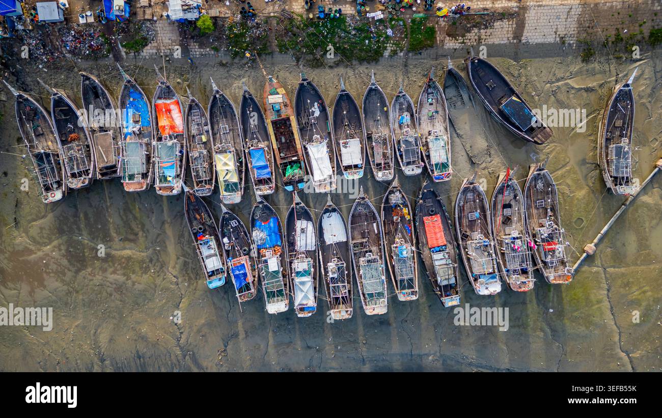 Attività di mercato al mercato del pesce di Chittagong con barche allineate e persone impegnate nel commercio Foto Stock