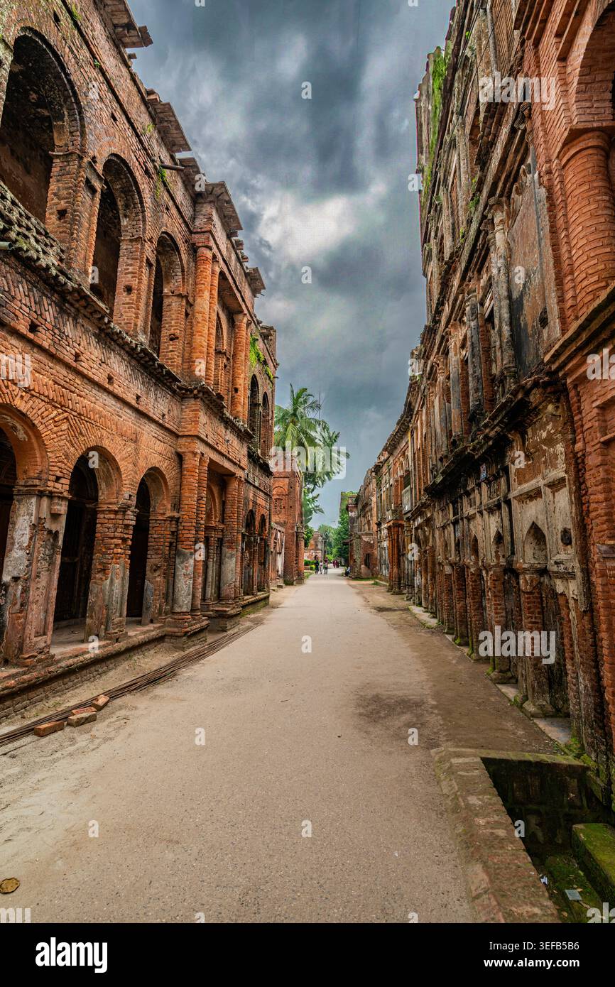 Edifici storici in mattoni fiancheggiano una strada tranquilla sotto un cielo nuvoloso in una zona della città vecchia durante il giorno Foto Stock