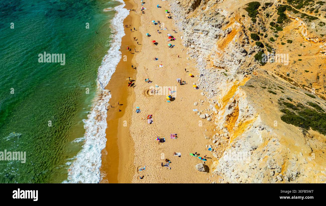 I visitatori possono godersi il sole e le attività sulla spiaggia di Tonel a Sagres, Algarve, Portogallo, con persone e ombrelloni sulla sabbia Foto Stock