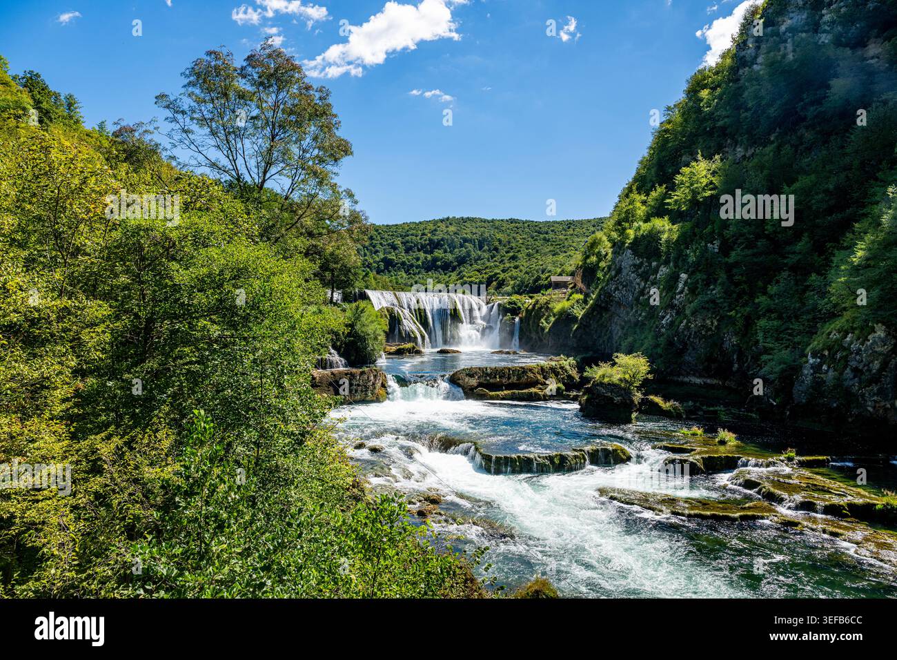 La cascata di Strbacki buk nel Parco Nazionale di una scorre su rocce e cascate attraverso gli alberi in una giornata di sole in Bosnia ed Erzegovina Foto Stock