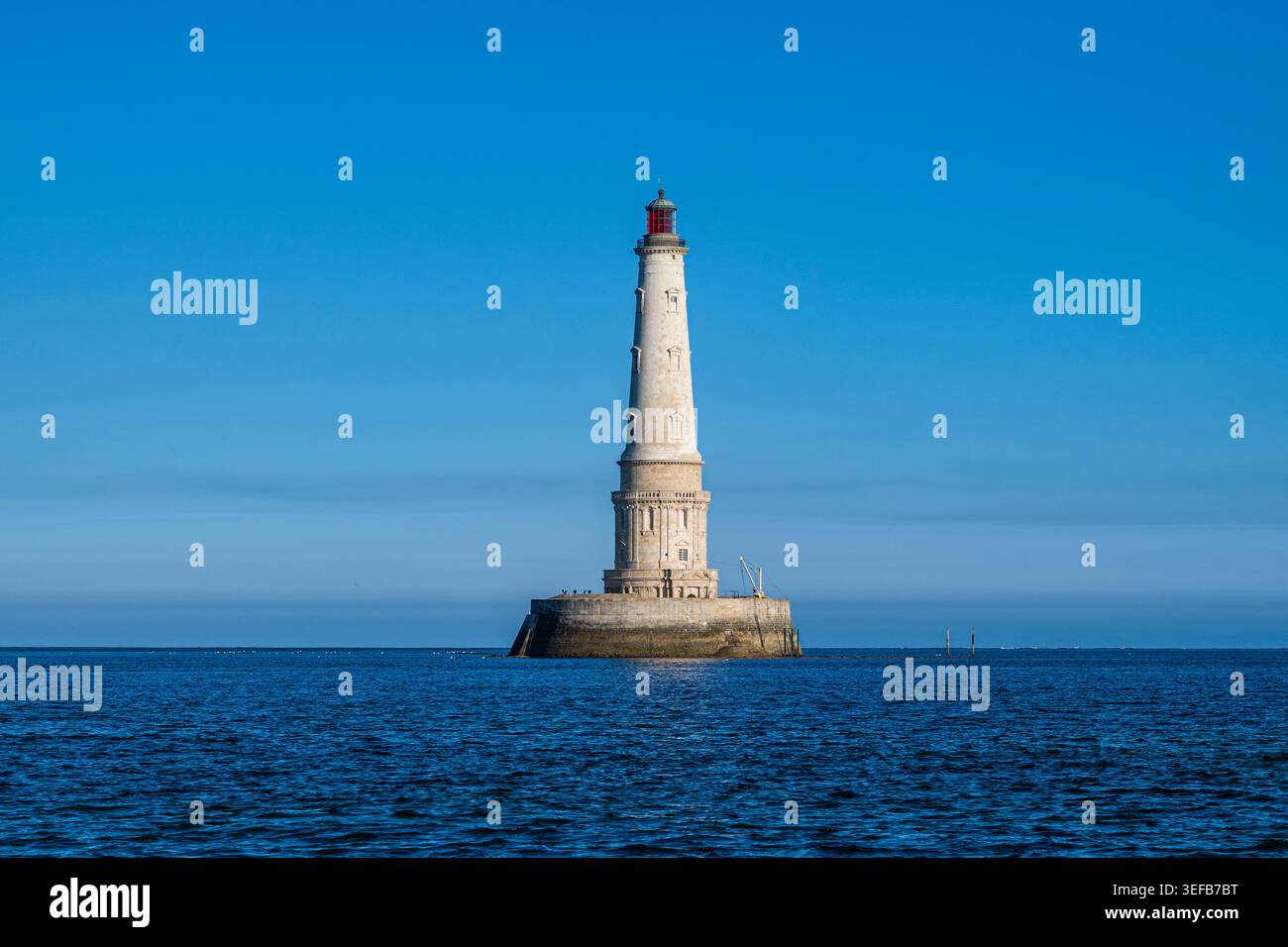 Visita lo storico faro di Cordouan in Francia, circondato da acque blu e cieli limpidi Foto Stock