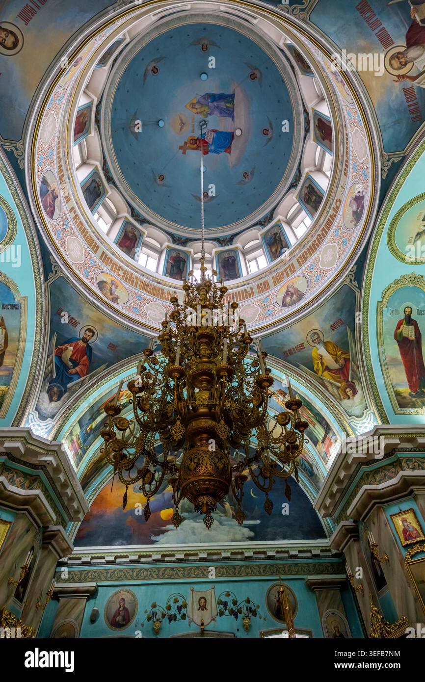 Vista interna della cattedrale di San Pietro e San Paolo con murales colorati e un grande lampadario a Gomel Foto Stock