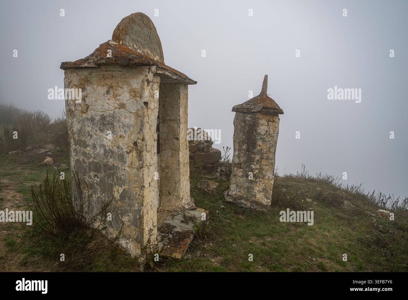 La nebbia copre le antiche strutture della Necropoli di Lezgor nell'Ossezia settentrionale, in Russia, in una giornata tranquilla Foto Stock