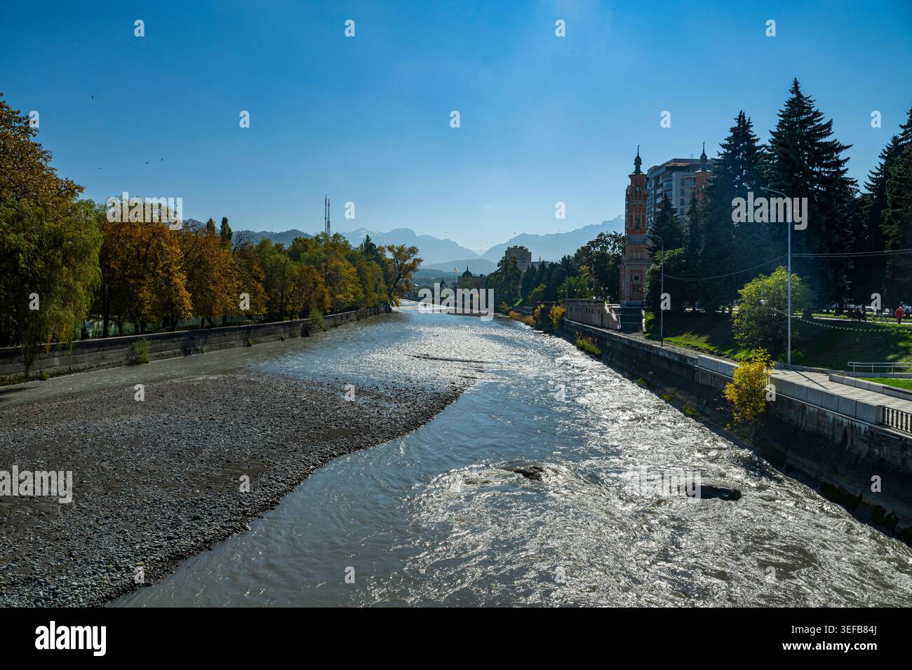 Il fiume Terek scorre attraverso Vladikavkaz con edifici e alberi sulle rive Foto Stock