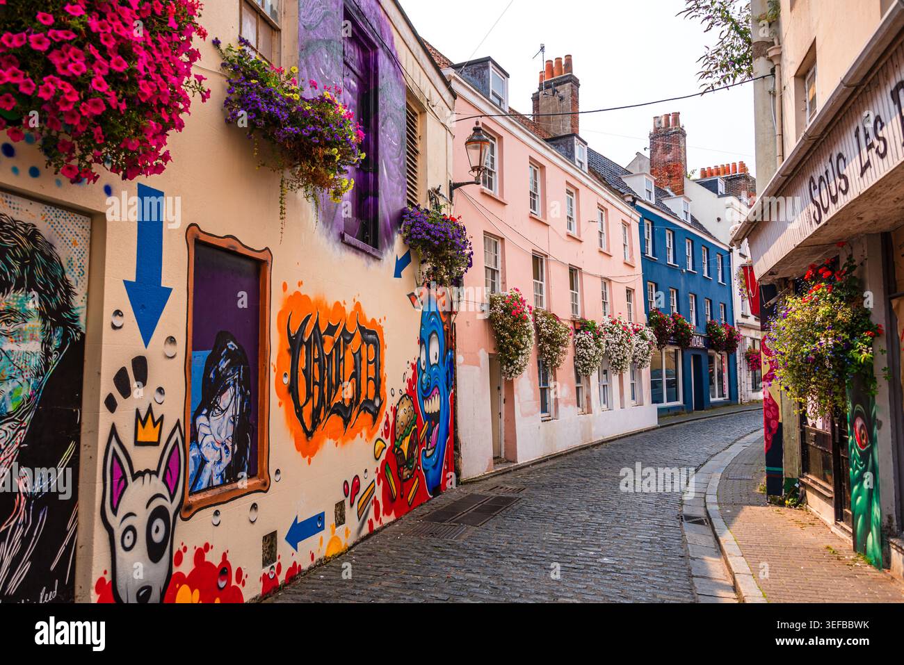 Vivace strada con murales e fiori nel porto di St. Peter al tramonto Foto Stock