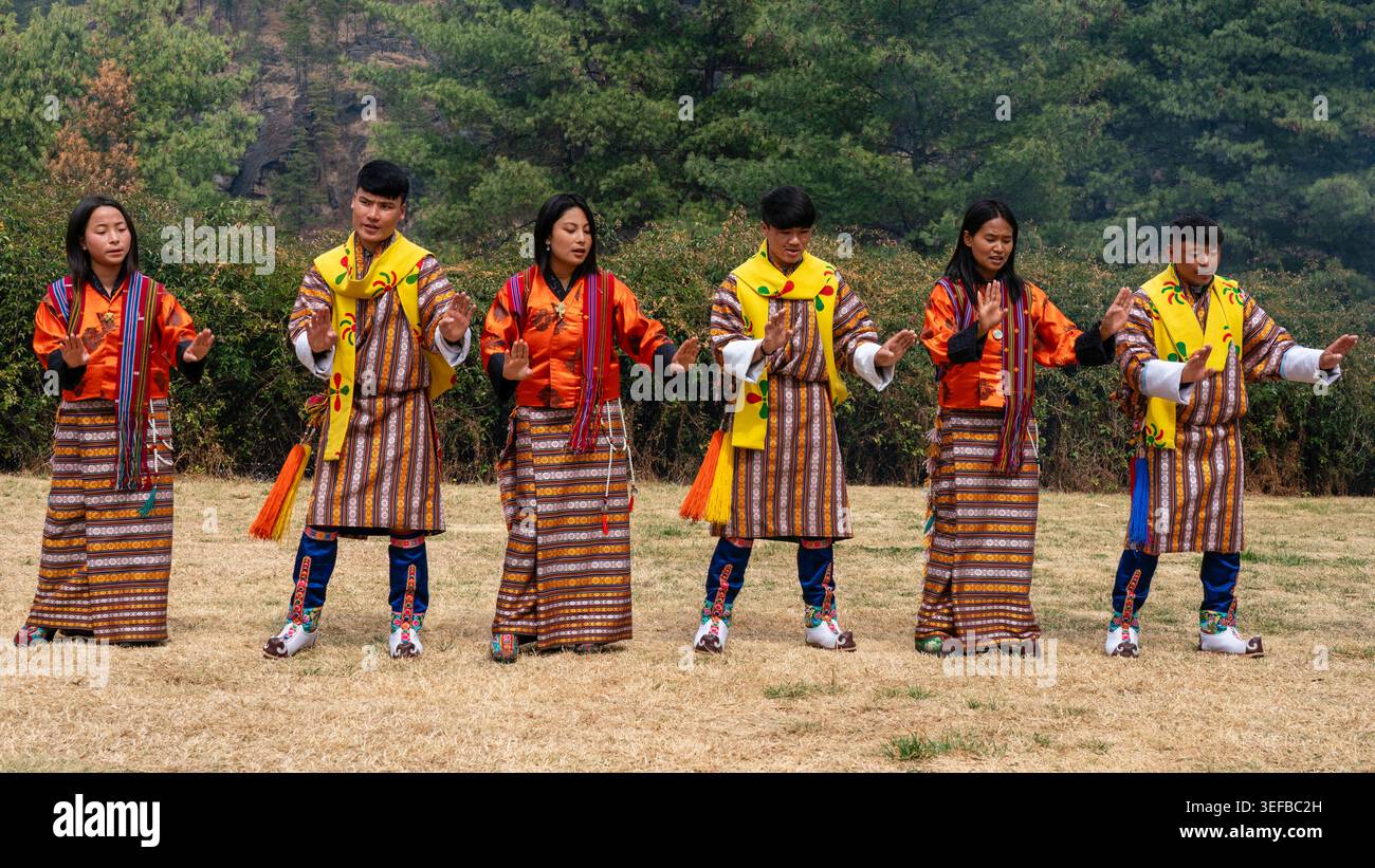 Il popolo bhutanese esegue danza tradizionale a Paro durante una celebrazione culturale sul campo Foto Stock