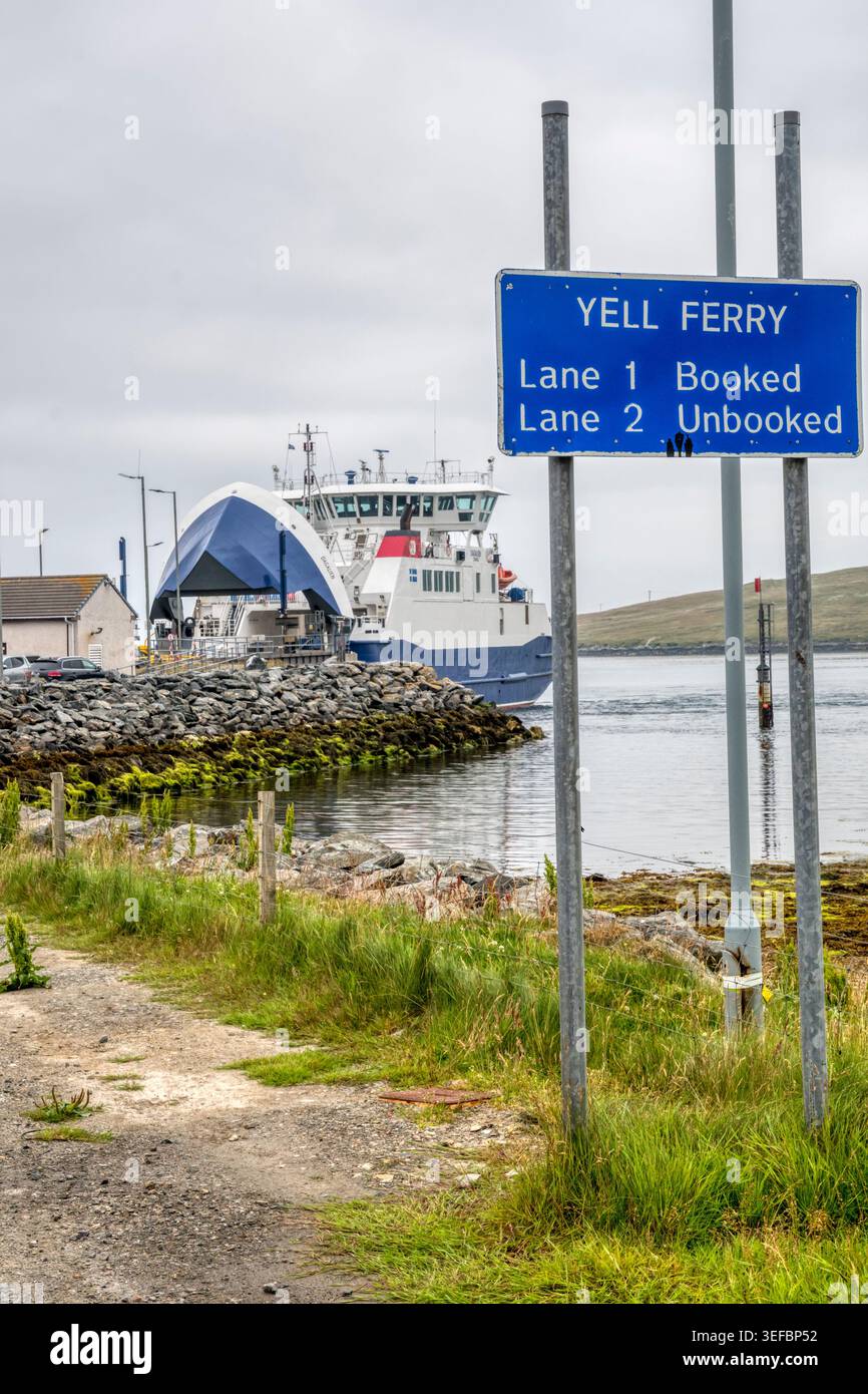 Cartello per il traghetto yell, con il traghetto sullo sfondo, a Toft sulla terraferma Shetland. Foto Stock