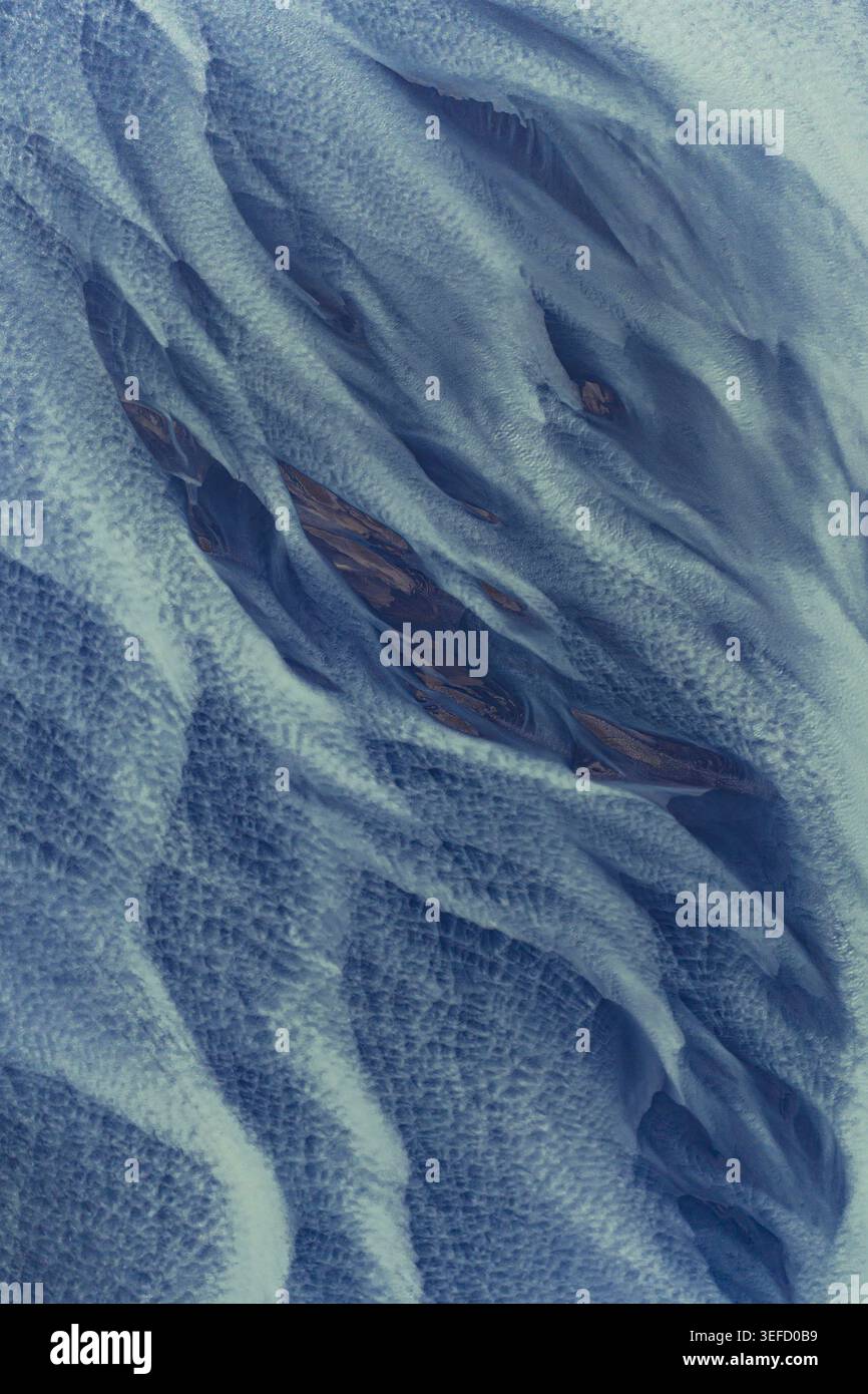 Vista aerea di intricati intrecciati modelli di fiume glaciale con acqua blu e sedimenti scuri a Hofn, Sveitarfelagid Hornaf, Islanda. Foto Stock