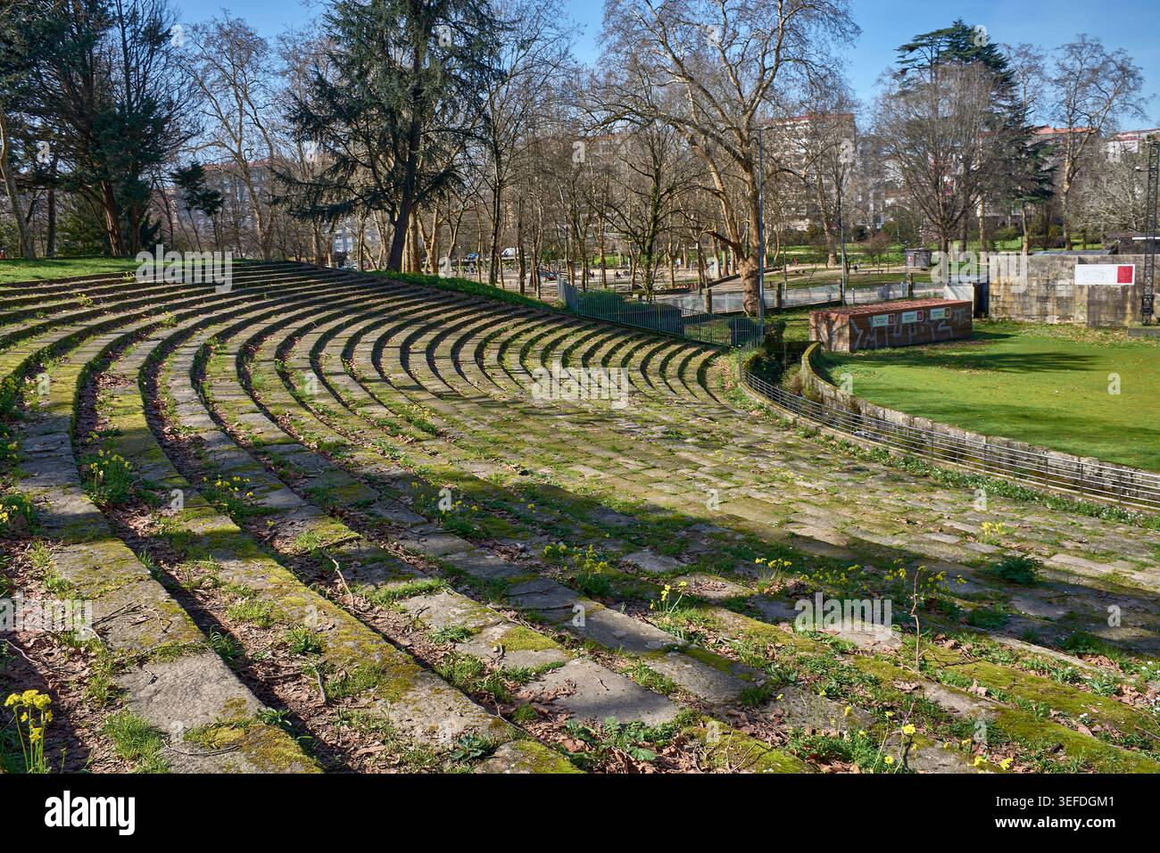 L'anfiteatro in pietra presenta i suoi posti a sedere semicircolari in una curva armoniosa che si fonde perfettamente con il paesaggio boscoso e i vivaci prati di CA Foto Stock