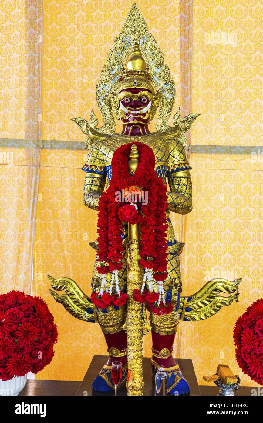 Tradizionale figura guardiana del tempio con armatura decorata in oro e decorazioni floreali rosse, isola sul fiume Koh Kret, Bangkok, Thailandia Foto Stock
