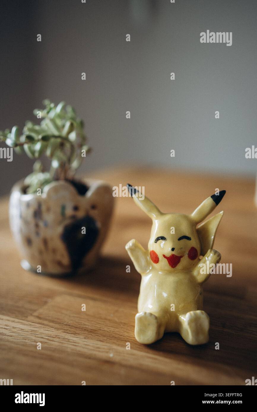 Simpatico mostro giallo anime fatto a mano con un viso sorridente e orecchie appuntite. Il personaggio del giocattolo in argilla in ceramica artigianale è perfetto per l'arredamento e il ventilatore della casa Foto Stock