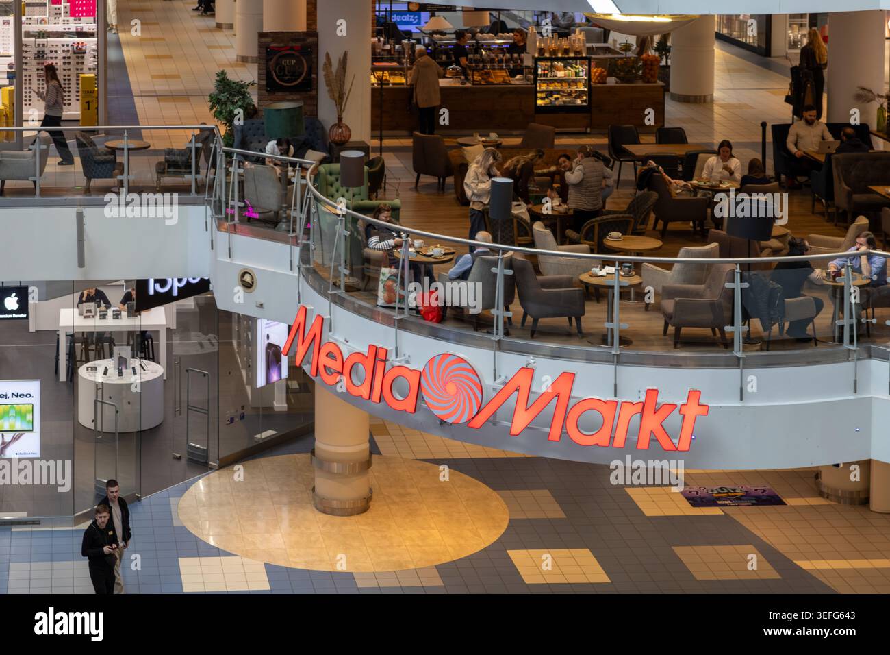 Varsavia, Polonia - 13 aprile 2026: Il marchio Media Markt appare all'interno di un centro commerciale contemporaneo con persone che socializzano ai tavoli e visitano Foto Stock