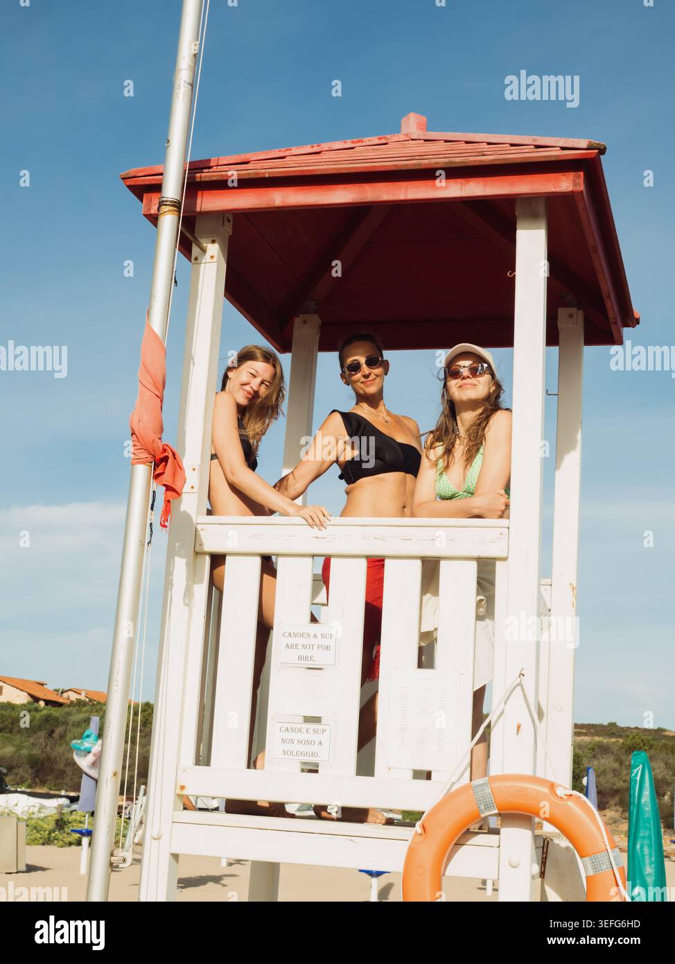 Tre donne in una torre bagnino in spiaggia, in Sardegna Foto Stock