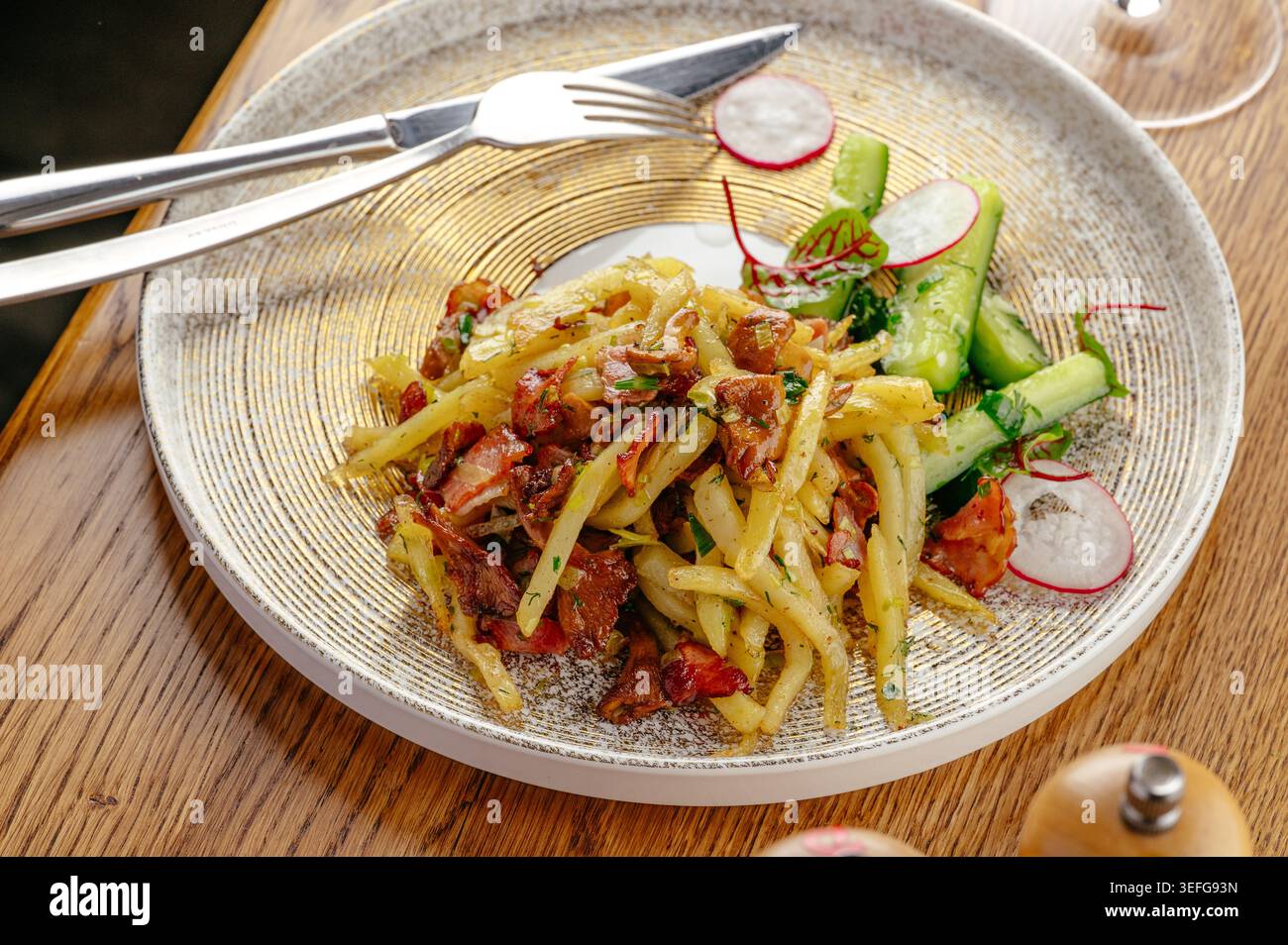 Patate fritte salate con pancetta e insalata fresca Foto Stock