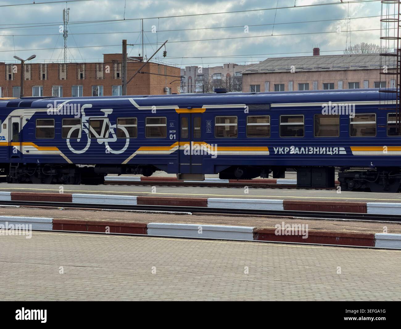 Chmelnytskyi, Ucraina - 30 marzo 2026: Carrozza blu per passeggeri Ukrzaliznytsia con simbolo della bicicletta per il servizio di trasporto durante il tra urbano Foto Stock