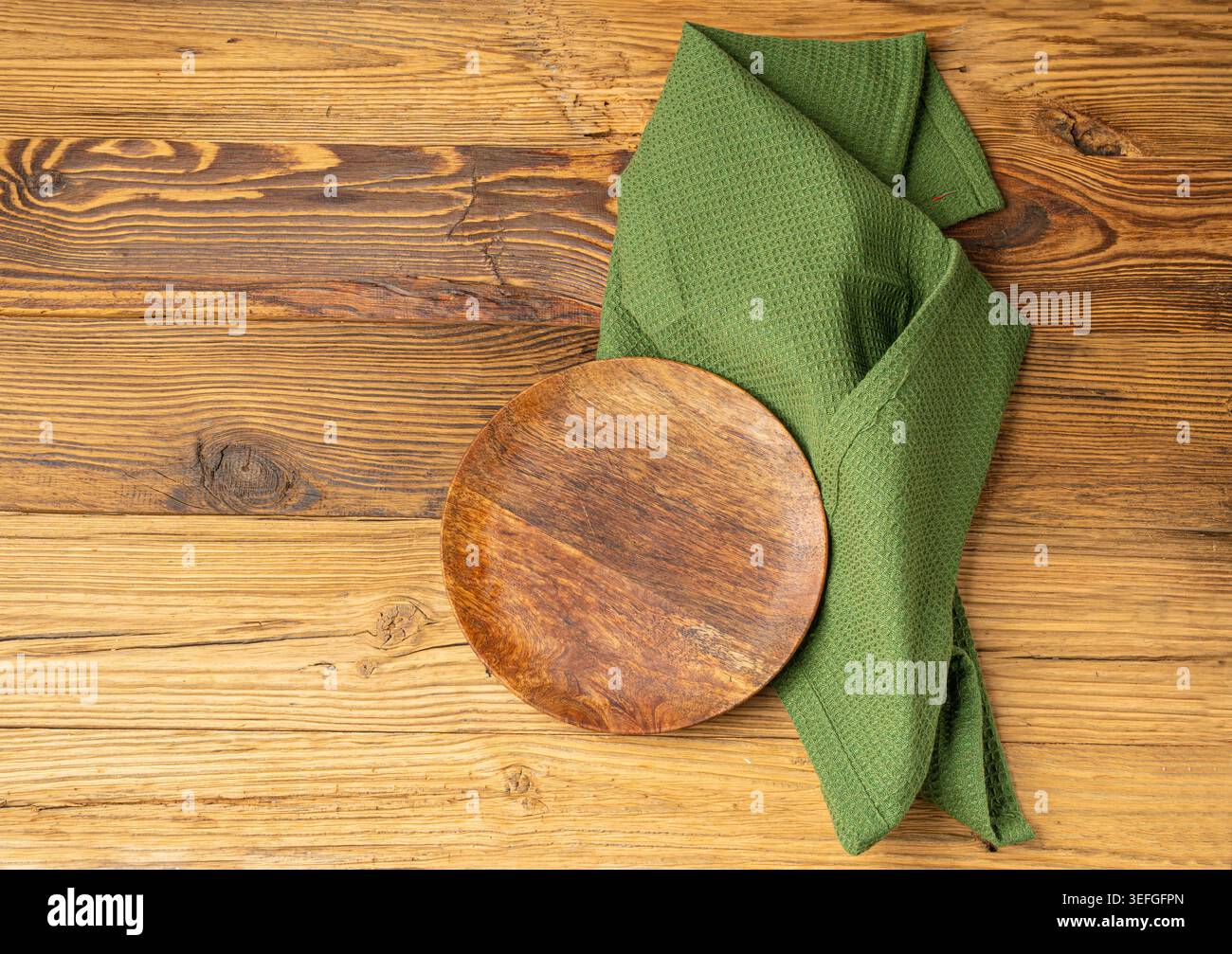 Placca vuota su tavolo in legno vista dall'alto con spazio per copiare il testo, tovagliolo rustico da cucina con tovagliolo verde, placca ecologica su tessuto tovagliolo Foto Stock