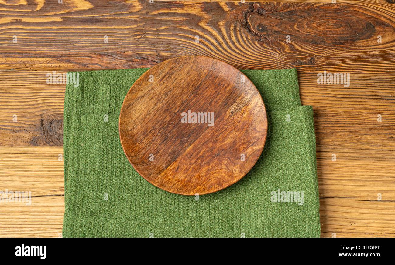 Placca vuota su tavolo in legno vista dall'alto con spazio per copiare il testo, tovagliolo rustico da cucina con tovagliolo verde, placca ecologica su tessuto tovagliolo Foto Stock