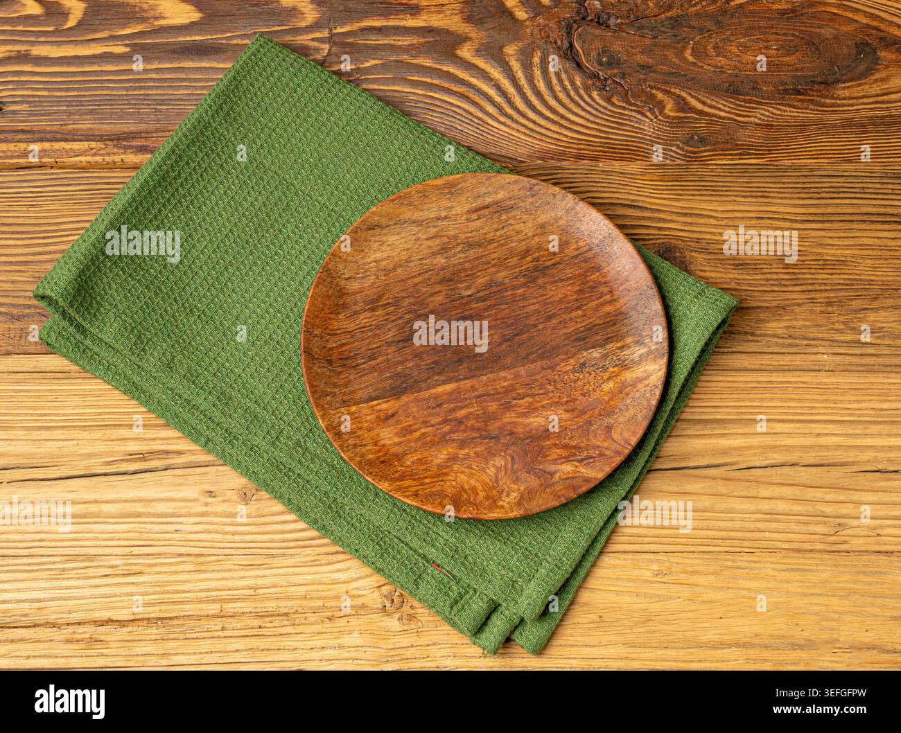 Placca vuota su tavolo in legno vista dall'alto con spazio per copiare il testo, tovagliolo rustico da cucina con tovagliolo verde, placca ecologica su tessuto tovagliolo Foto Stock