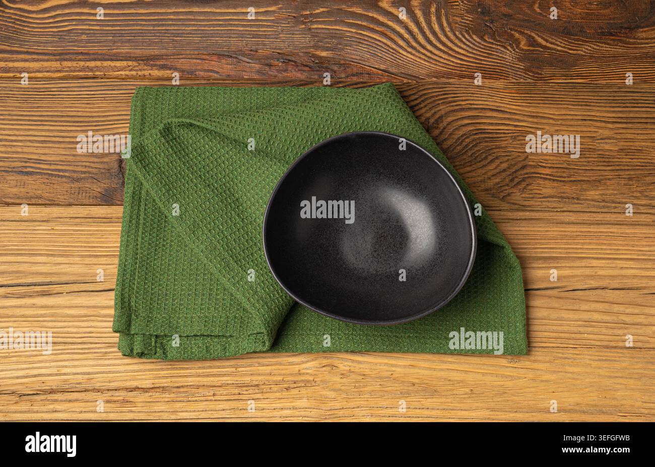 Mockup ciotola vuota, piatto nero su tavolo in legno vista dall'alto con spazio per copiare il testo, camicia da cucina rustica, ciotola vuota con tovagliolo in tessuto Foto Stock