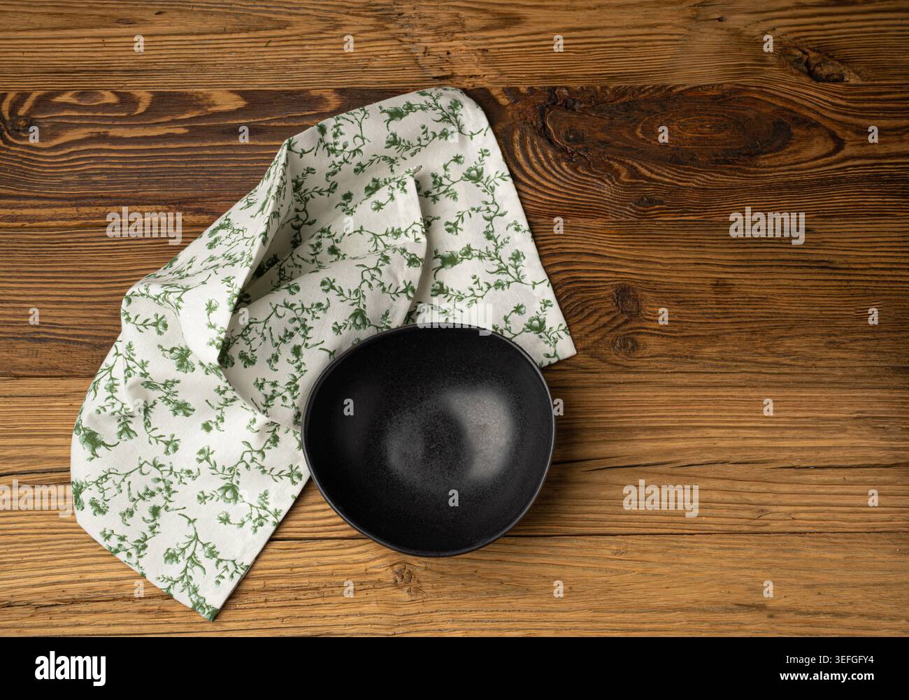 Mockup ciotola vuota, piatto nero su tavolo in legno vista dall'alto con spazio per copiare il testo, camicia da cucina rustica, ciotola vuota con tovagliolo in tessuto Foto Stock