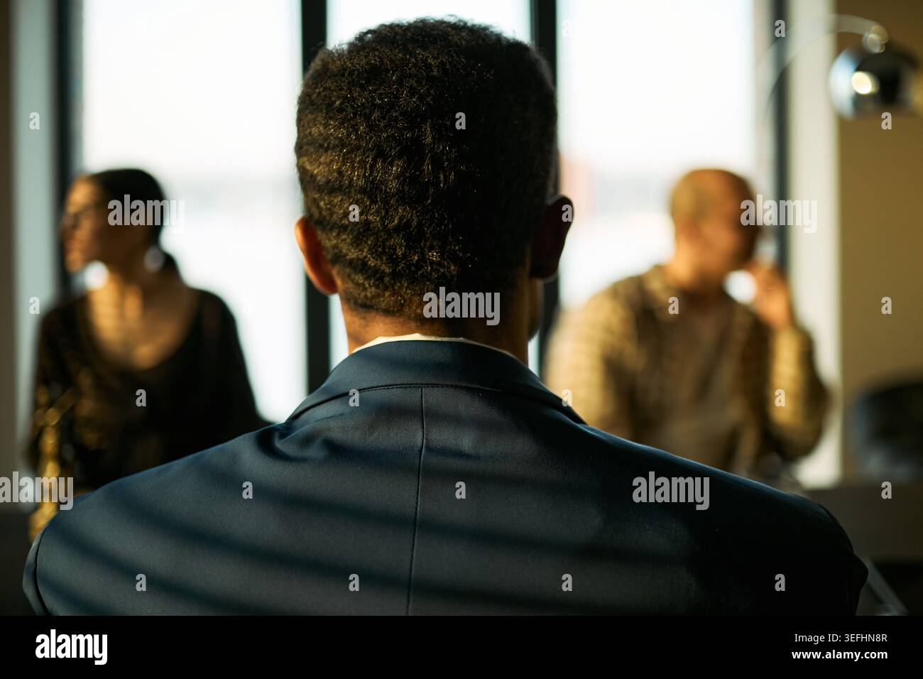 Vista posteriore dell'uomo di mezza età seduto tra una coppia separata durante la mediazione del divorzio, discutendo la risoluzione dei conflitti e il supporto legale. Ideale per il diritto di famiglia e la consulenza al marketing Foto Stock
