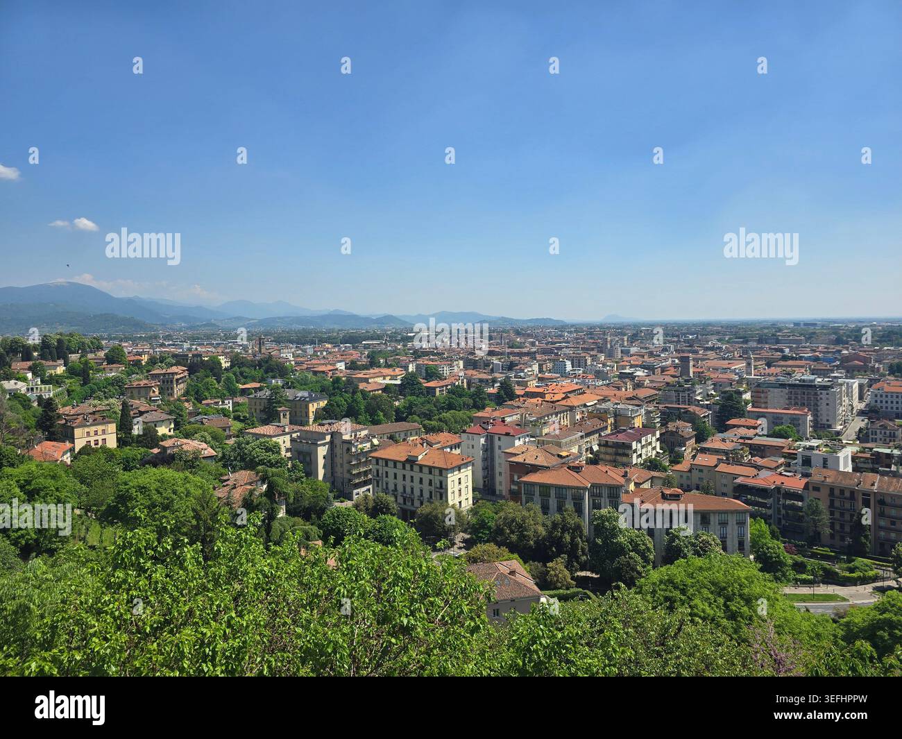 Ampia vista panoramica sui tetti della bassa Bergamo verso le colline alpine da Bergamo alta, Lombardia, Italia Foto Stock