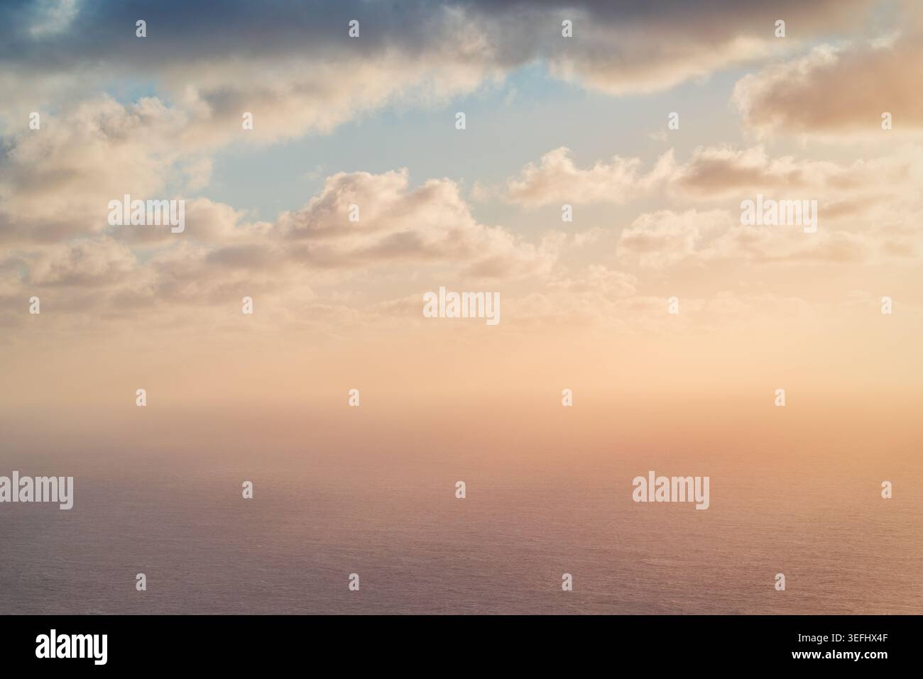 Tramonto da sogno sull'oceano con soffici nuvole e foschia dorata Foto Stock