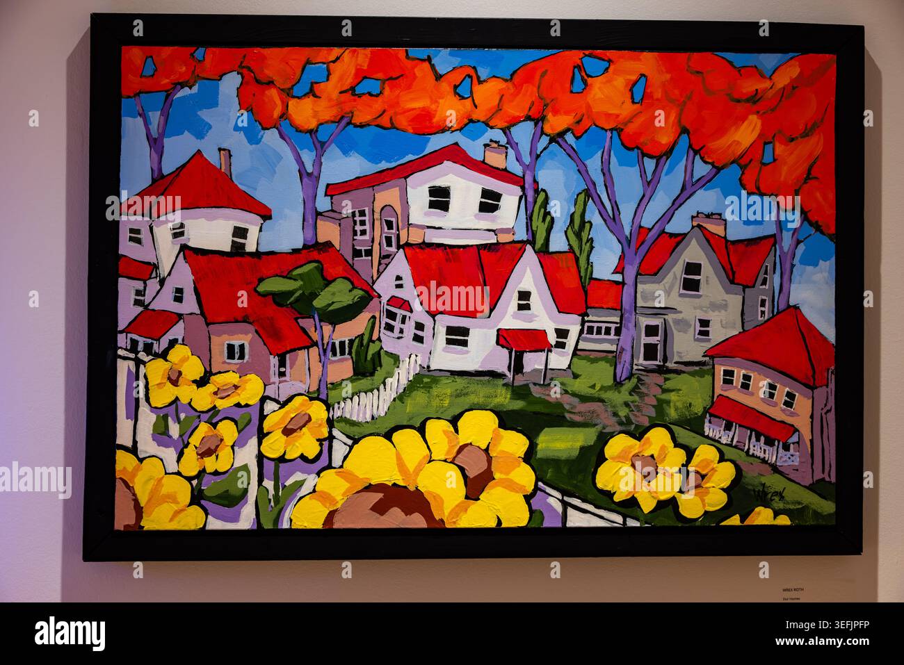 Colorato paesaggio del villaggio con case dal tetto rosso e fiori gialli Foto Stock