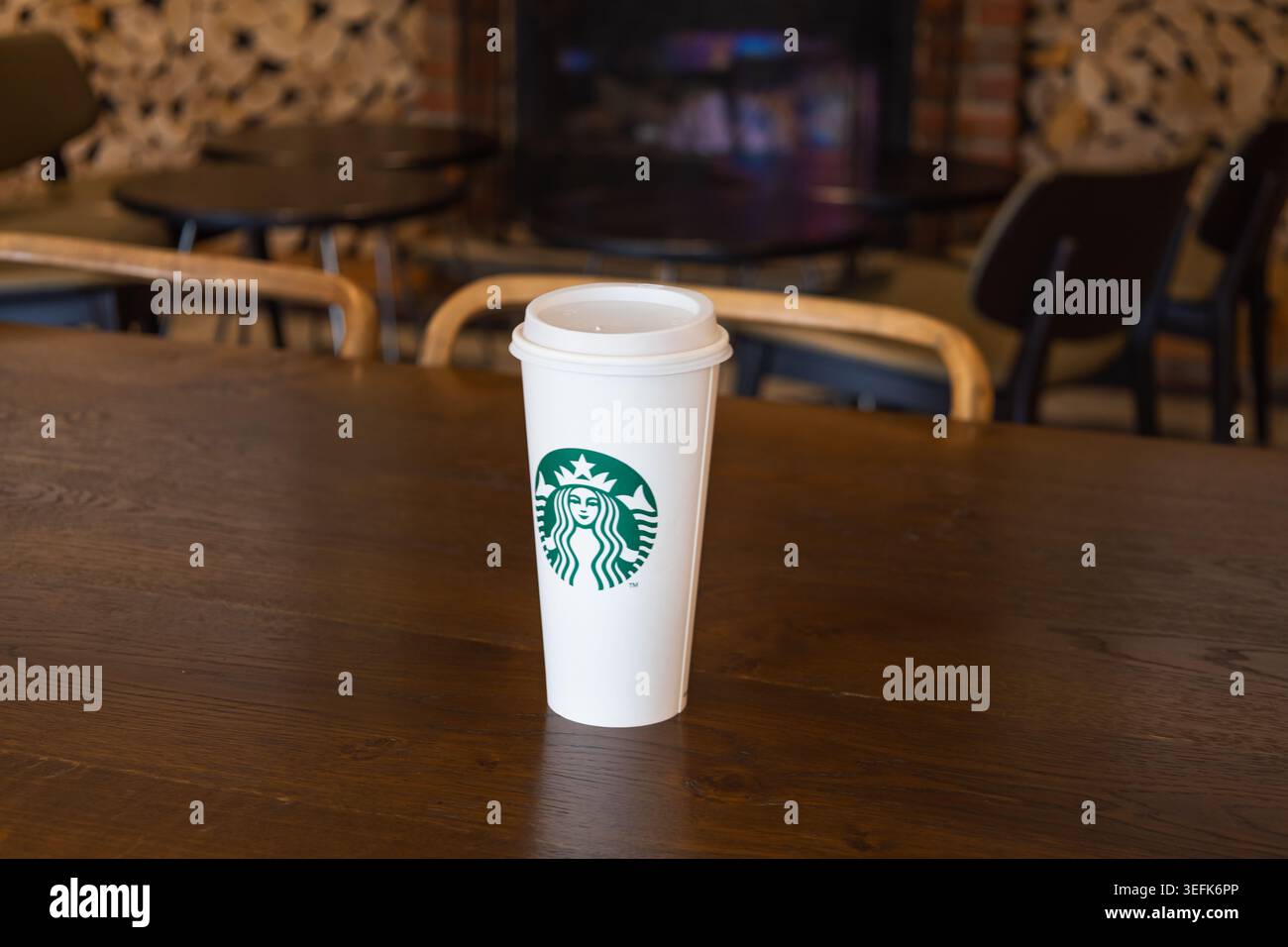 Tazza da caffè Starbucks su un tavolo di legno in un accogliente ambiente da caffe'. Londra, Regno Unito, 3 luglio 2024 Foto Stock