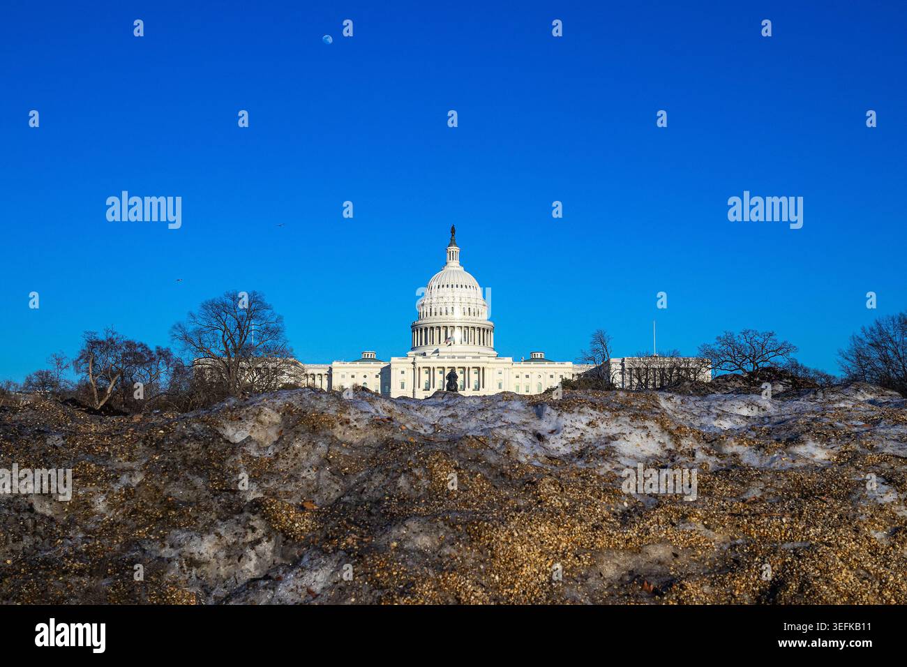 Il Campidoglio degli Stati Uniti dietro un mucchio di neve sporca a Washington DC, in inverno Foto Stock