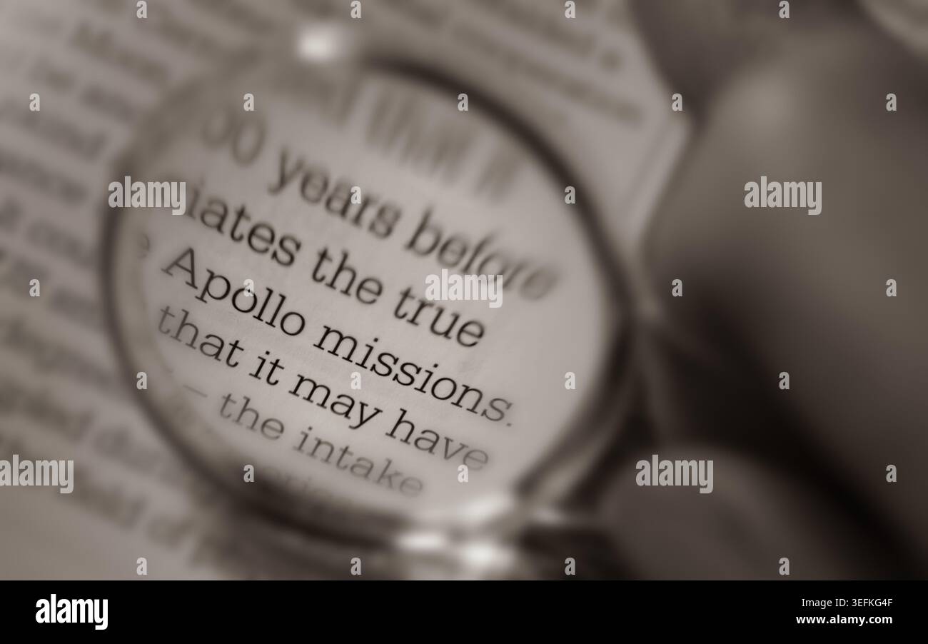 "Missioni Apollo" testo visto attraverso una lente d'ingrandimento tenuta in mano sulla pagina del libro Foto Stock