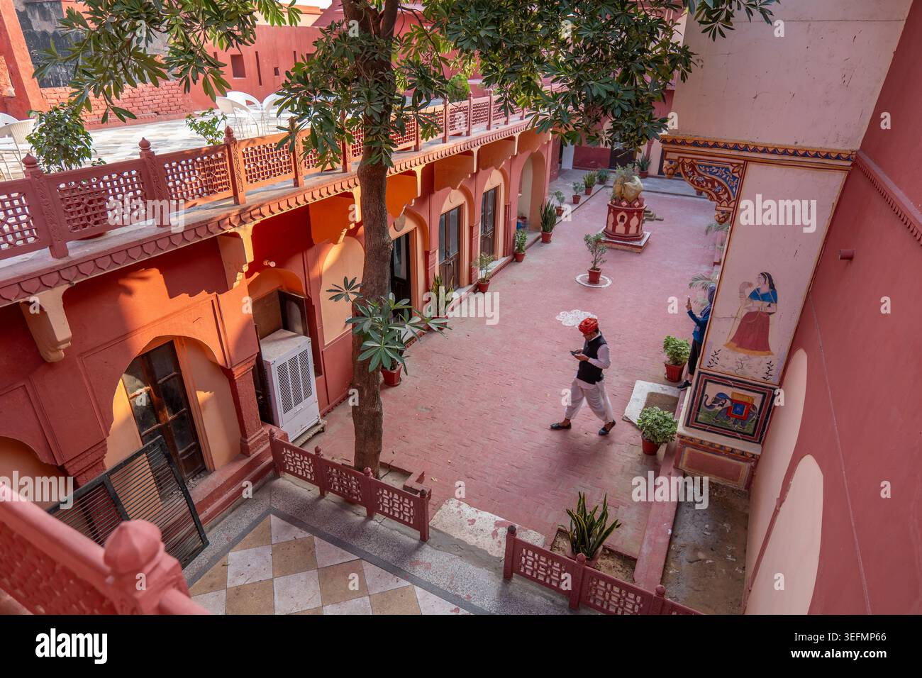 Cameriere che attraversa il cortile dell'hotel Fort Madhogarht Foto Stock